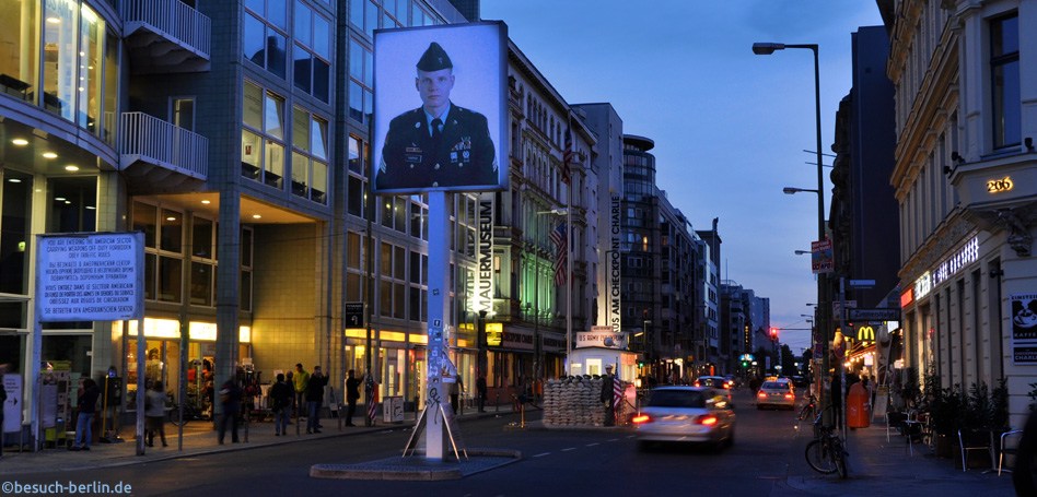 Bild: Nachtaufnahme des Checkpoint Charlie mit Blick Richtung Kreuzberg