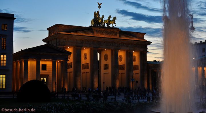 Brandenburger Tor in Berlin mit Brunnen in Abendstimmung